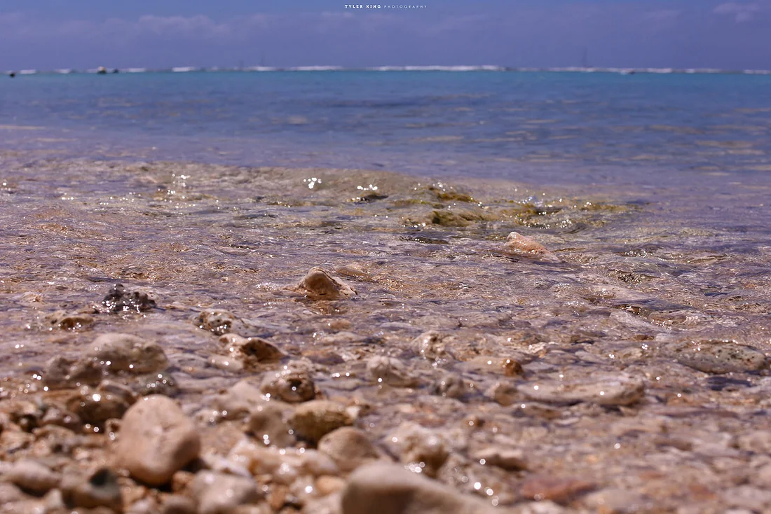 Clear water along a rocky Hawaiian shoreline, photographed by Tyler King